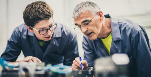 Image of an older worker sharing information with a younger co-worker